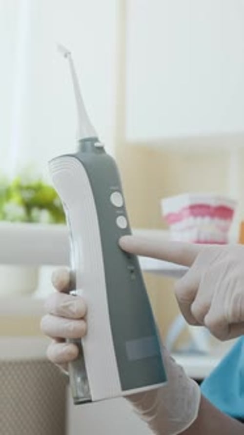 Hand Pressing Power Button on Water Flosser