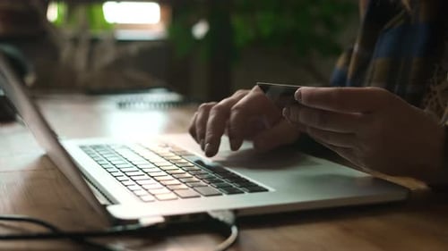 Paying Online Hands Geben Sie Bankzahlungskartendaten mit dem Laptop ein