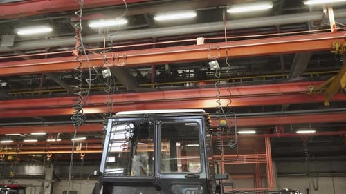Chaîne de montage de tracteurs avec cabine sur le lieu de travail dans une grande usine