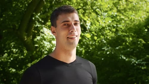 Young Man Jogging in Sunny Park Enjoying a Healthy Outdoor Workout