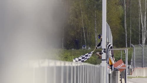 Checkered Flag Waving at Car Race Finish Line