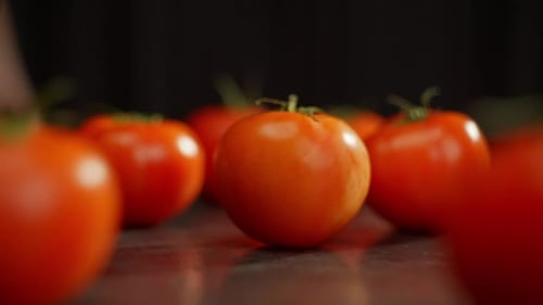 Vídeo en cámara lenta de un tomate girando sobre una mesa, entre otros
