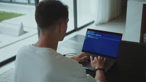 Programmer Typing Code on Laptop in Home Office in Natural Light Coding and Software Development