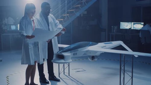 Deux ingénieurs aérospatiaux travaillent sur un prototype de véhicule aérien sans pilote/Drone. Des scientifiques de l'aviation discutent
