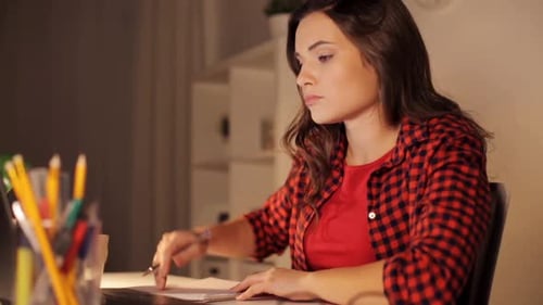 Focused woman studies using laptop at her desk