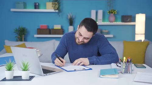 Young man working from home happily working.