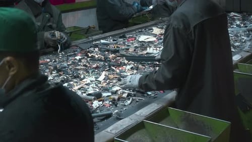 Workers Sorting Recycled Material on Conveyor Belt