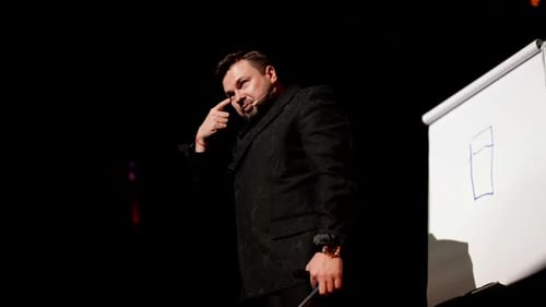 Motivierender Business-Coach bei einer modernen Veranstaltung Der Redner spricht das Publikum auf der Bühne an: Ein Erwachsener