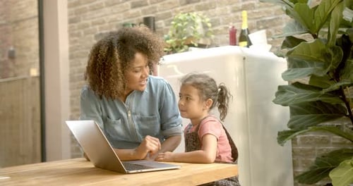 Woman and Child Using Laptop Outside