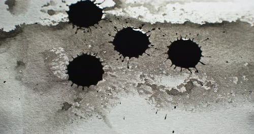 Black Ink Drops Splattering on White Paper