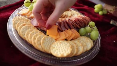 Gros plan d'une femme préparant un délicieux pique-nique à base de charcuterie en plein air sur la plage. Fromage, c