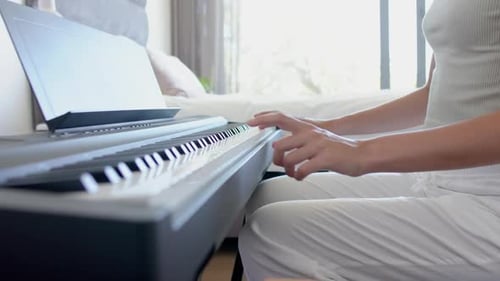 Woman Playing Electric Piano at Home During Day