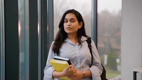 Smiling Student Holding Books Inside University Library
