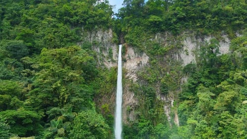 Majestic Tall Waterfall Cascading Down Rocky Cliff in Costa Rica Rainforest