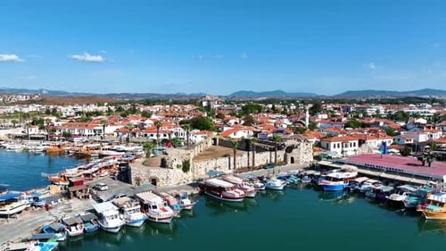 Vue aérienne depuis un drone de la jolie ville égéenne de Sigacik avec son château historique, ses bateaux dans le f
