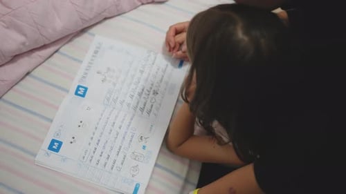Children in Poor Family Doing Homework at Home with Mother on Bed