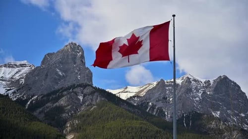 Canadian Flag Waving in Mountain Landscape
