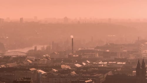 The orange haze hanging above Prague obscuring the view. Smoke rising above the rooftops and from th