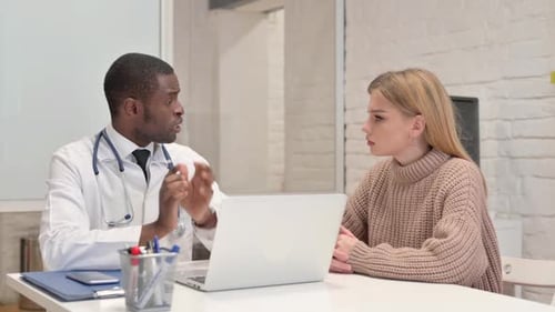 African Doctor Talking with Patient in Clinic