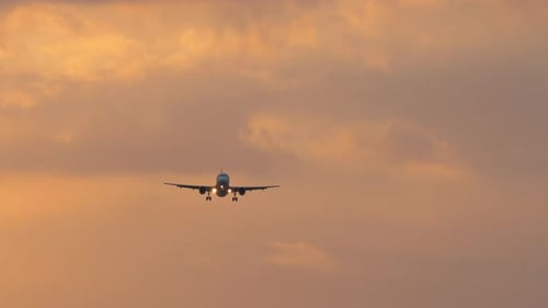 Airplane Landing During Golden Hour Sunset