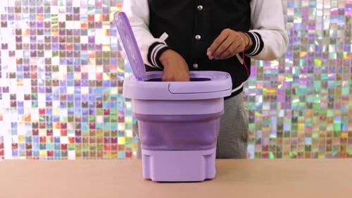 Clothes Being Placed into Portable Washing Machine