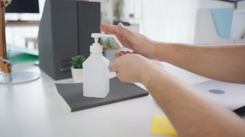 Close up of young businessman use hand sanitizer gel for clean hands.