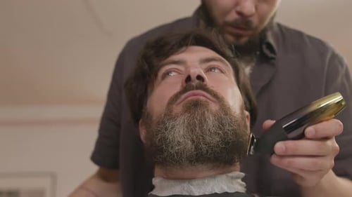 Man Getting Beard Trimmed by Barber Indoors
