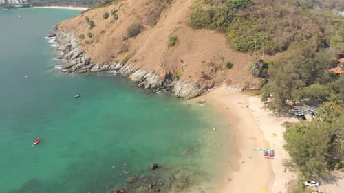 Rocky shoreline and exotic landscape of Yanui Beach next to Promthep Cape - Aerial low angle Fly-ove