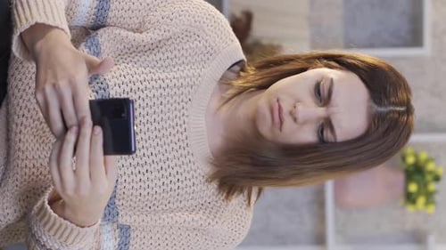Woman Looking at Cell Phone with Confused Look