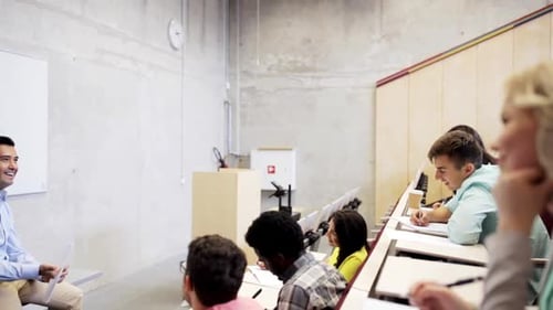 International students and teacher discussing education in university lecture hall