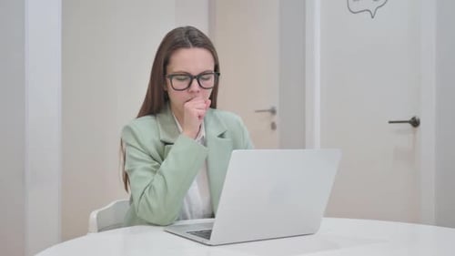 Business Woman Working at Laptop Coughs