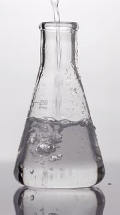 Clear Liquid Pouring in Glass Flask – Laboratory Experiment