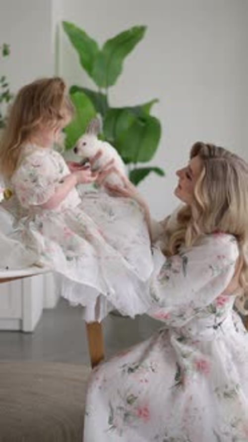 Mother and Daughter with White Rabbit Concept of Family Interaction Tenderness Spring Day