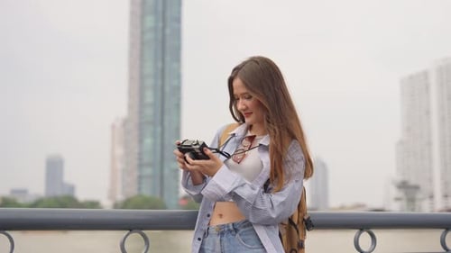 Asian woman traveler use camera taking a photo while traveling in city.
