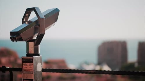 A coin operated binocular with a blurry view of the sea
