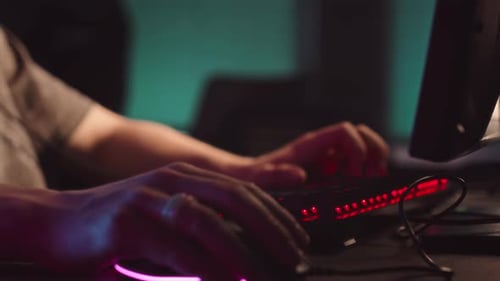 Hände des Spielers, der Maus und Tastatur beim Spielen in der Nacht benutzt