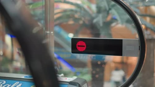 People Steps Off Moving Walkway with Red Stop Indicator in Mall