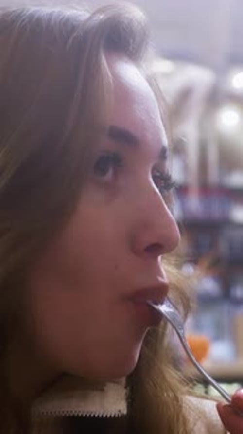 Closeup Calm Woman Enjoying Creamy Croissant with Whipped Cream and Fruit in Cozy Cafe