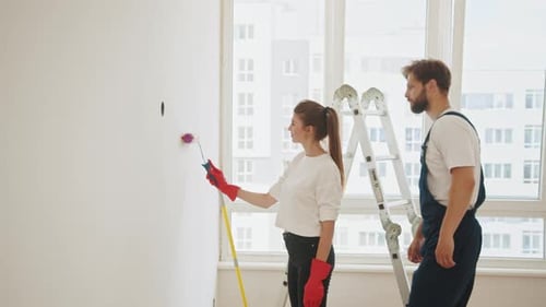 Couple Painting Apartment Together in Sunny Room