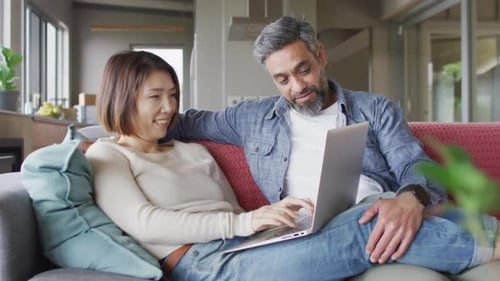 Couple Relaxing on Couch with Laptop Computer