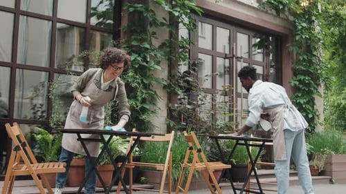 Cheerful Diverse Cafe Workers Wiping Tables Outdoor