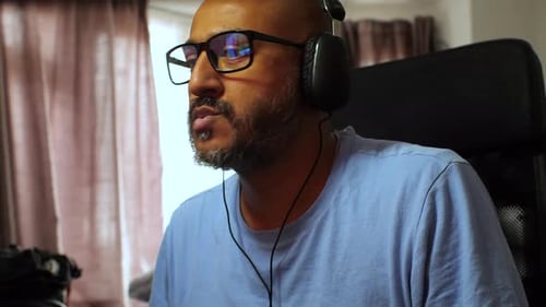 South Asian Man Listening to Music at Home with Headphones Bopping Head