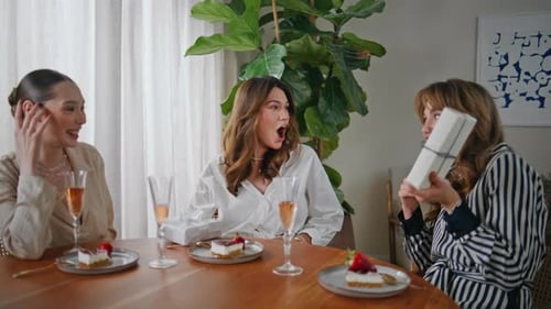 Young Women Celebrating Birthday with Cake and Gifts