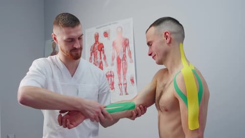 Doctor Applies Kinesiology Tape to Patient's Arm