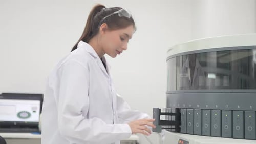 Woman working with medical testing machine in laboratory