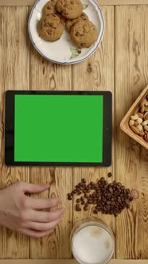 Vertical of Crop Nervous Person Tapping Fingers Near Tablet and Breakfast Food