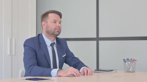 Man in Suit Thinking at Desk