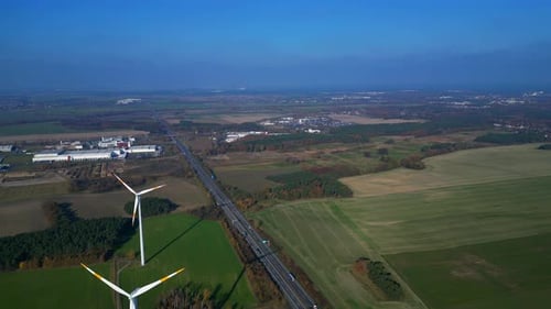 Wind farm Windmill turbines near highway clean energy. Unique aerial view flight drone