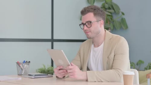 Man on Video Call Using Tablet in Office