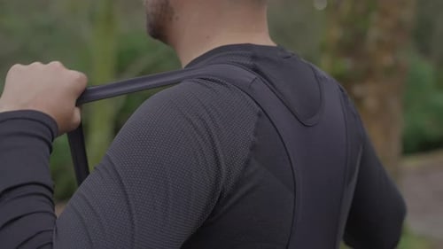 Cyclist adjusting cycling vest collar before ride close up